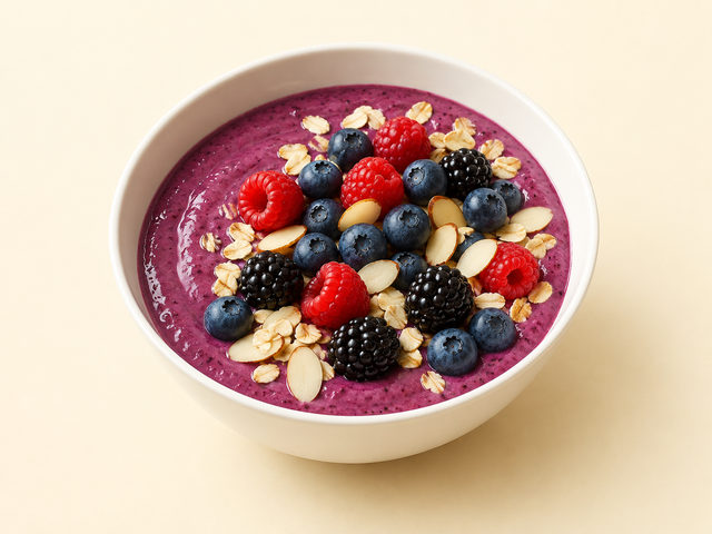 Smoothie bowl viola con frutti di bosco, avena e mandorle